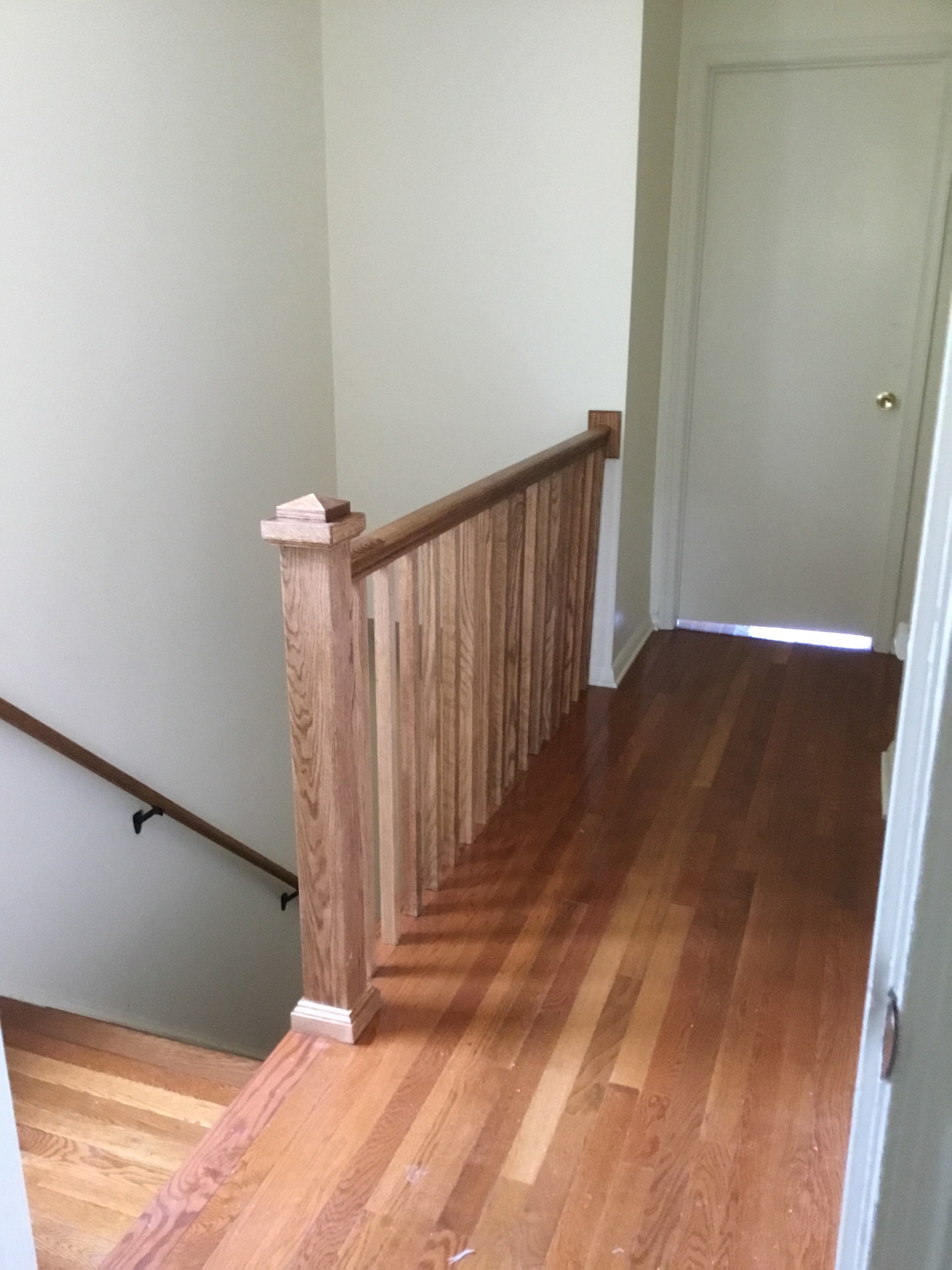 Bannister wood railing with pickets installation in Bethesda, MD. It is stained to match existing wooden floor.