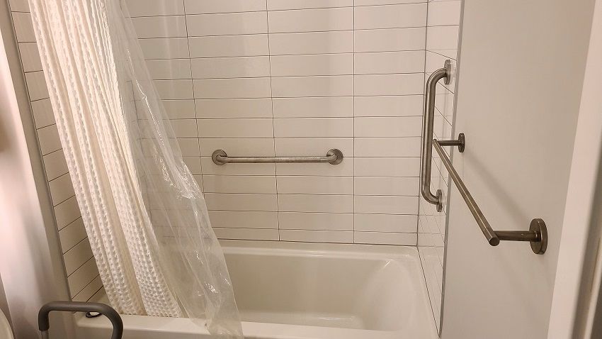 Designer grab bars installation in a bathroom in Potomac, MD.  One grab bar is insalled vertically and two are horizontal for support when using the bathtub.
