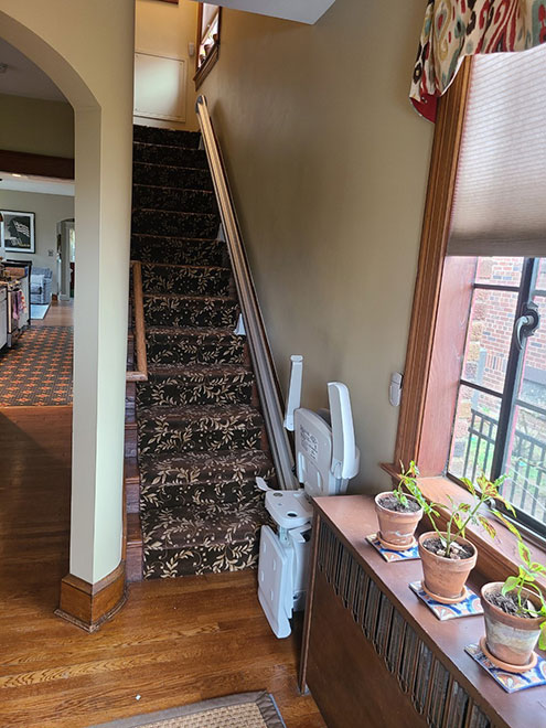 Image of an indoor Straight stairlift installed in Northwest DC on the right side of staircase. It is a Brunno SRE 3050 model